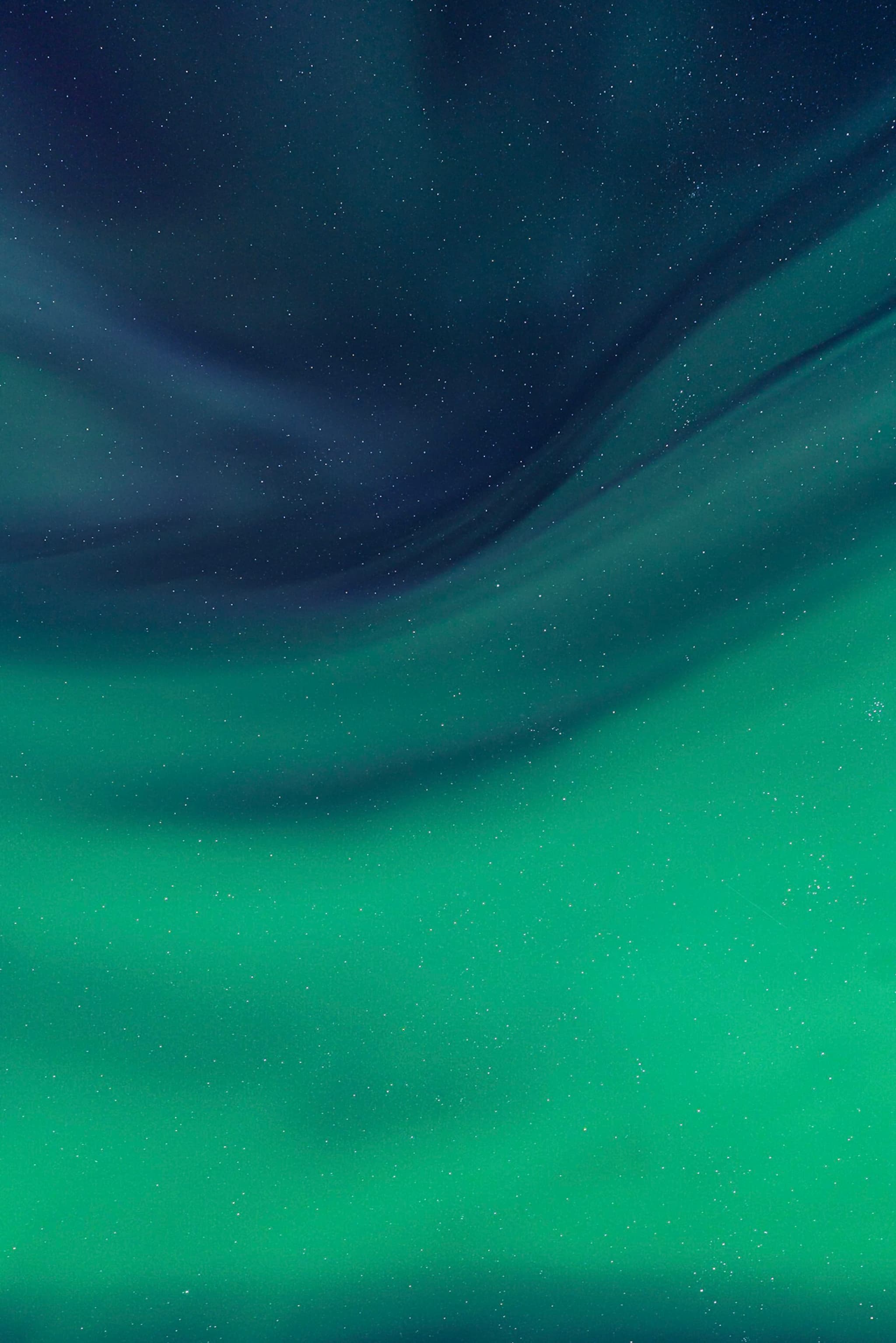 Abstract swirl of deep blue and glowing green gradients resembling a soft aurora in the night sky