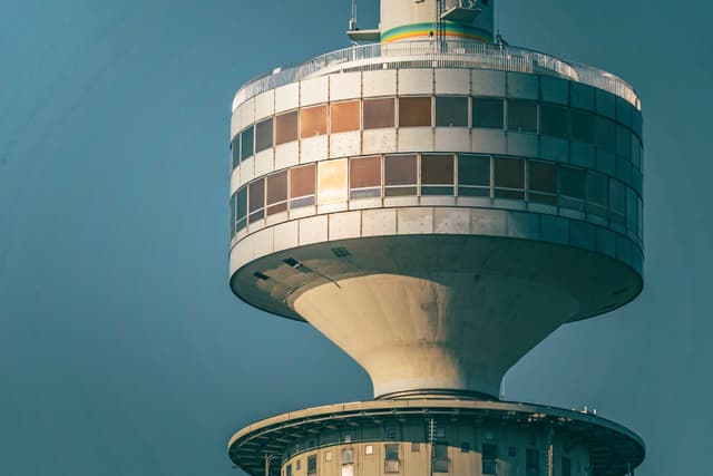 Close-up of a modern cylindrical tower with stacked observation decks against a clear blue sky
