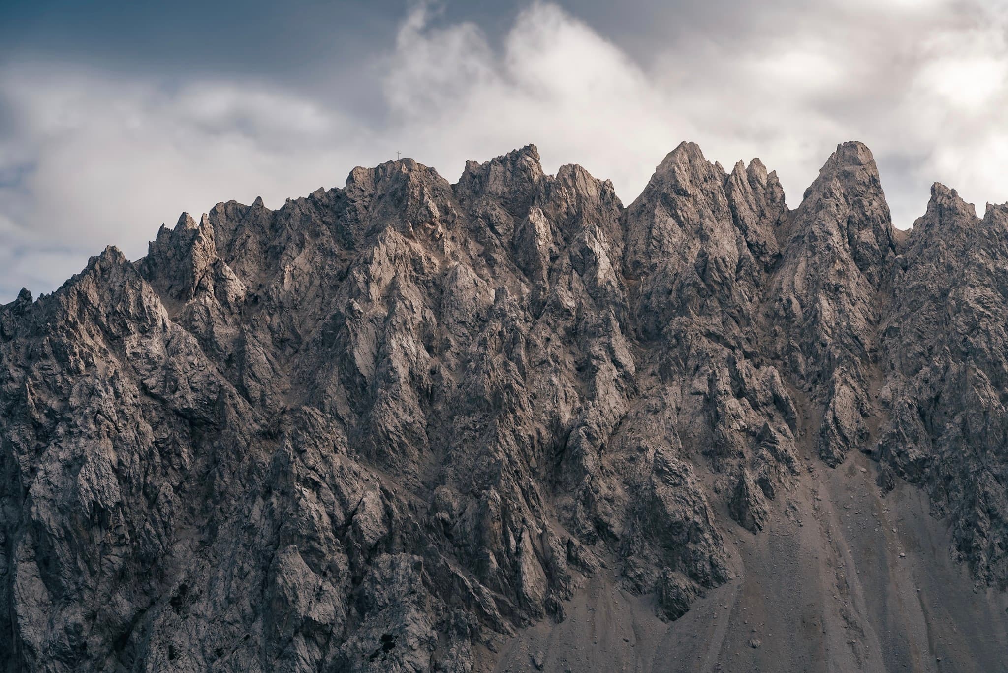 Sharp rocky mountain ridge under a cloudy sky