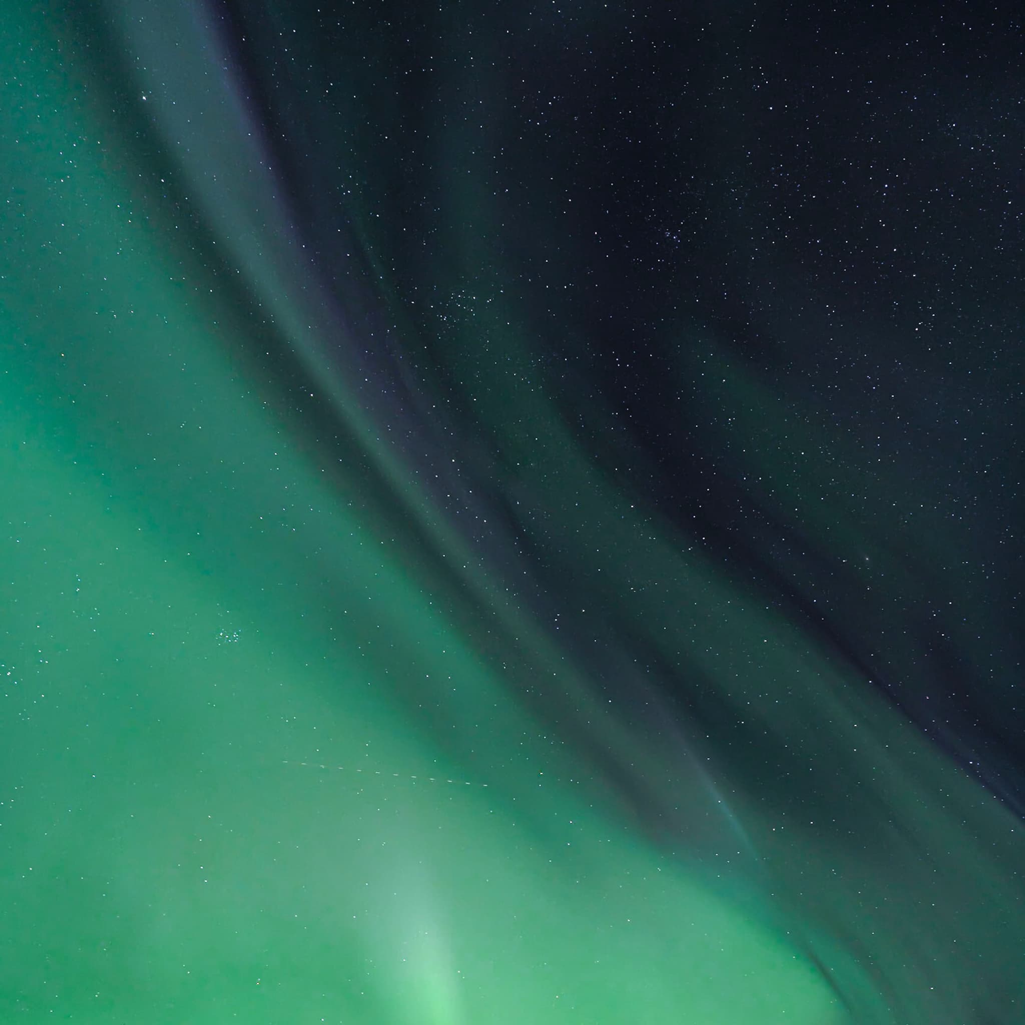 Green aurora borealis curtains sweeping across a starry night sky